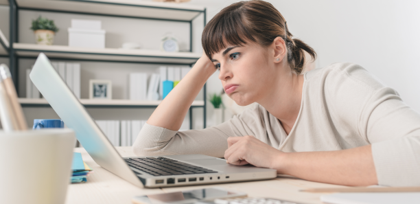 disappointed woman working at office desk with a laptop