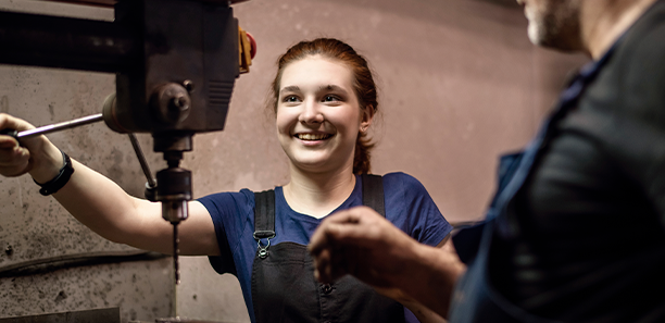 Apprentice working with a mechanical drill