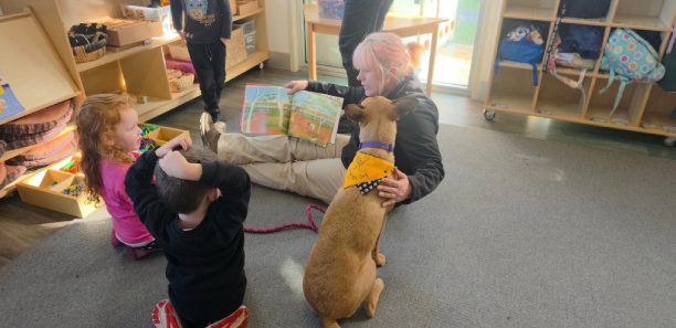 Norah with Kimberley at a daycare centre reading books with young children