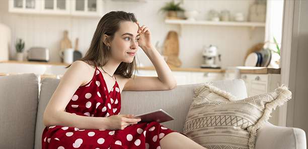 Young adult female thinking with tablet in hand