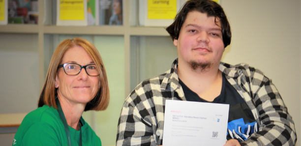 Foundation Studies student receiving his ticket from staff member Claire