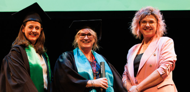 Lisa (centre) receiving her certificate onstage at the TAFE Gippsland 2025 Graduation Ceremony with CEO Laura Macpherson and teacher Jan-Maree Constantine