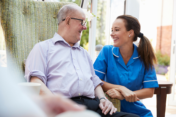 Aged care worker sitting next patient