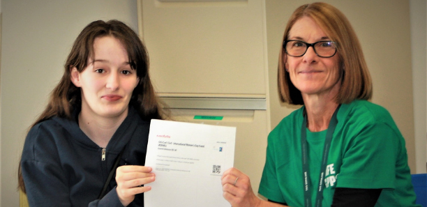 Foundation Studies student receiving her ticket from staff member Claire