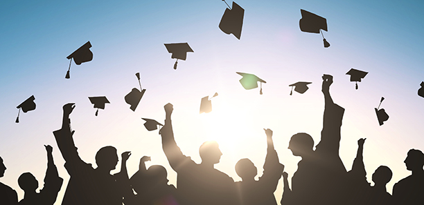 Graduates holding their caps in the air