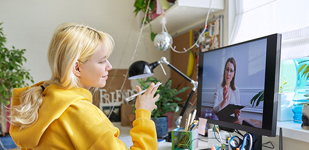 Teenage student female talking, writing, studying, looking at teacher on computer monitor screen. Virtual meeting, distance learning, e-education, individual online lesson, tele video technologies